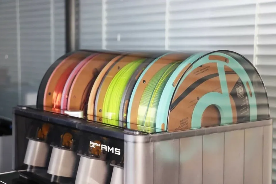 Polymaker photograph of cardboard spools with adapter rings inside an AMS.